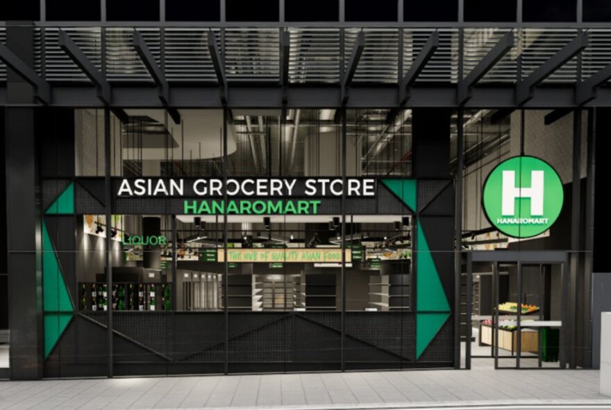 Shop facade in modern arcade with green and white signage and black-framed windows.