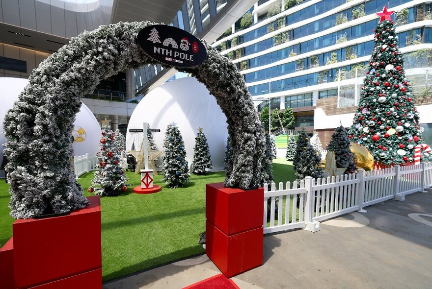 An archway through to a Christmas pop-up with igloos and trees.