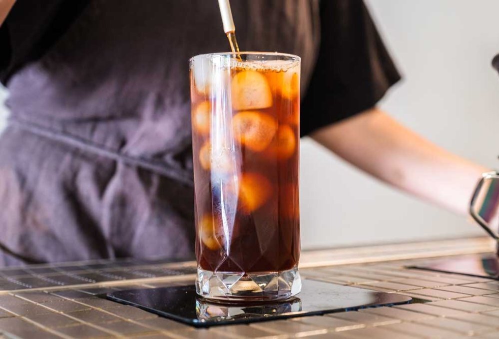 A glass filled with ice cubes and black coffee