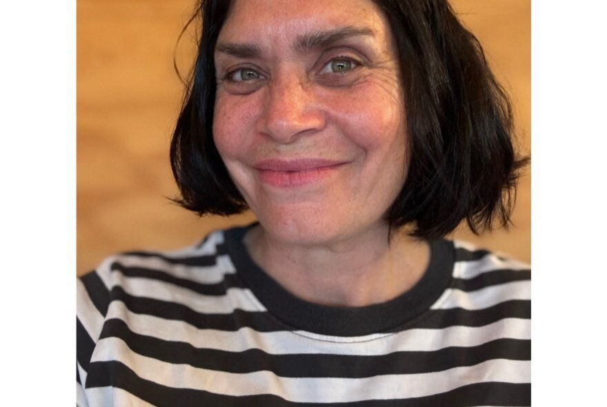 Woman with short dark hair and striped top.