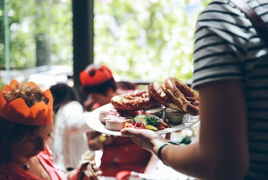 A Christmas dish of food being delivered to a table of people.