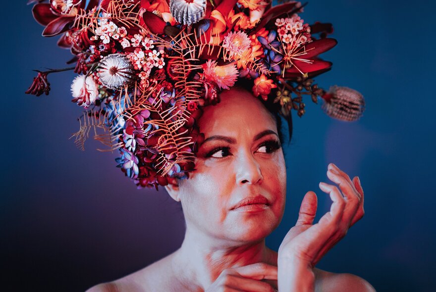 Torres Strait Islander singer-songwriter Christine Anu, wearing a red-toned floral headdress.