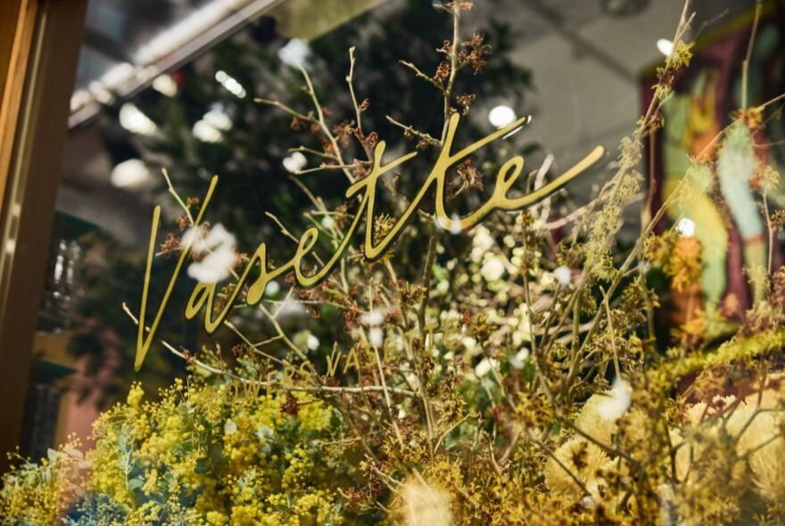 Brown floral displays in window with signage.