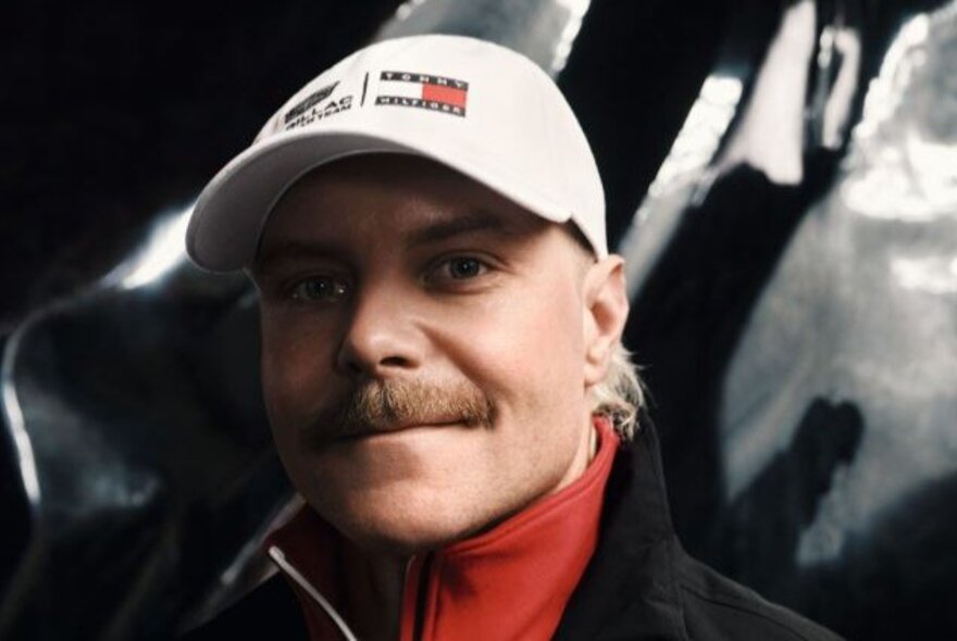 Formula 1 driver Valtteri Bottas wearing a white Tommy Hilfiger cap.