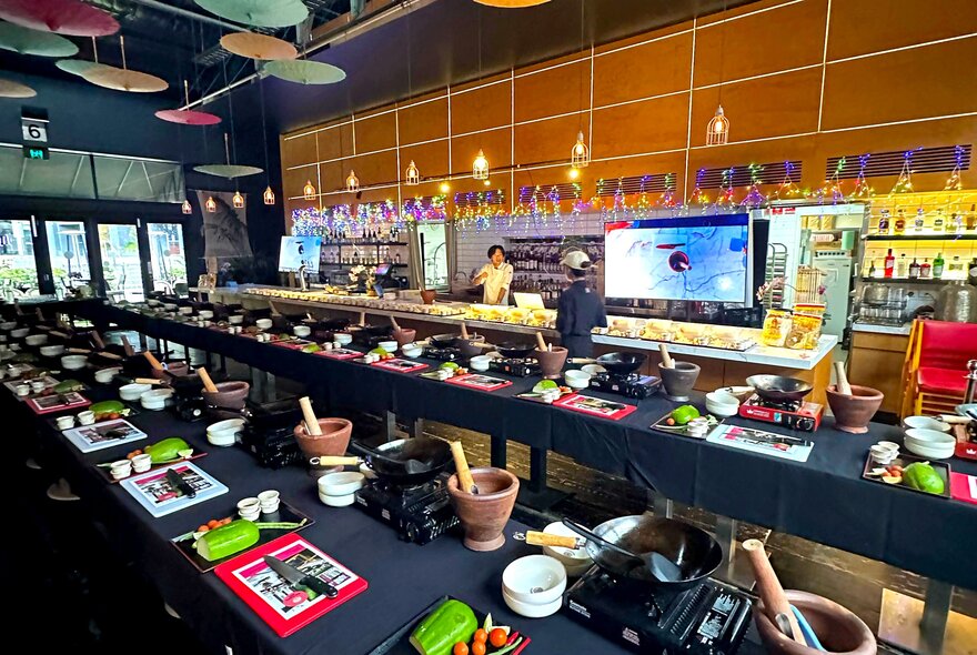 Long counters set up for a food workshop in a restaurant setting with bowls and utensils.