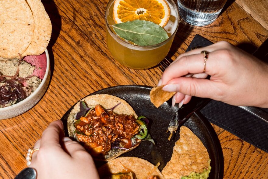 Looking at a table with hands reaching for tacos.