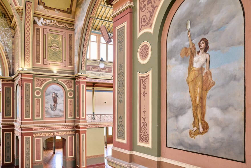 The ornate interior of Royal Exhibition Building with prominent arched murals and decorative paint work on the walls and ceilings.