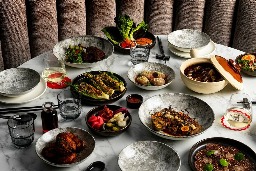 Marble table loaded with dishes of food.