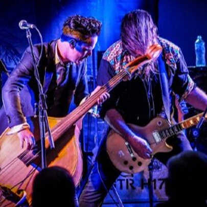 Musicians performing on stage with guitar and double bass.