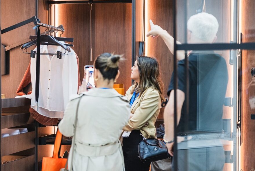 People looking at wardrobe solutions at a kitchen and bath design expo.