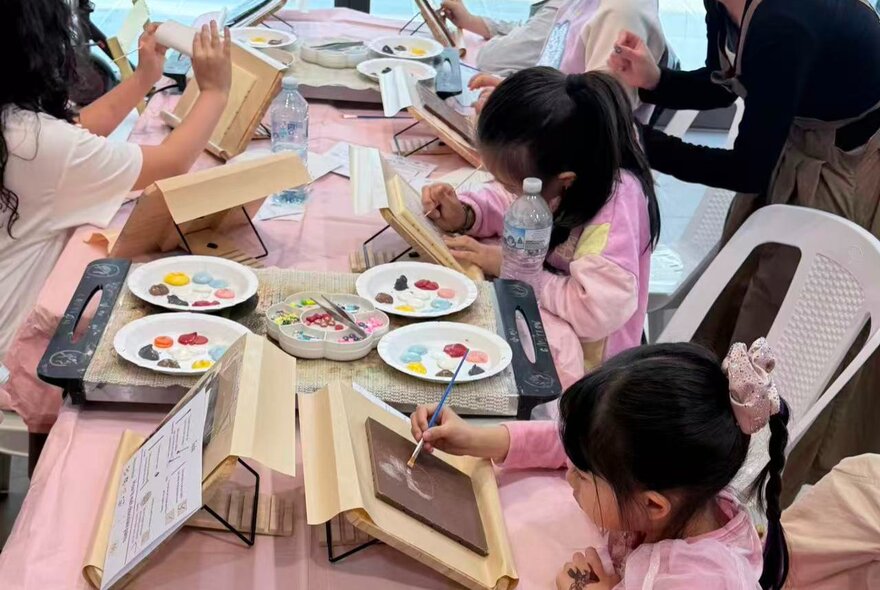 Children participating in a chocolate painting workshop.
