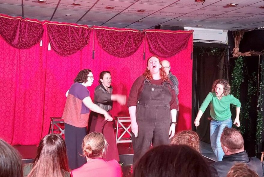 Actors improvising on a stage in front of an audience.