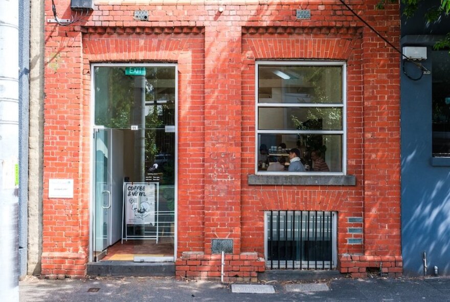 The exposed red brick exterior of Cafe Tomi.