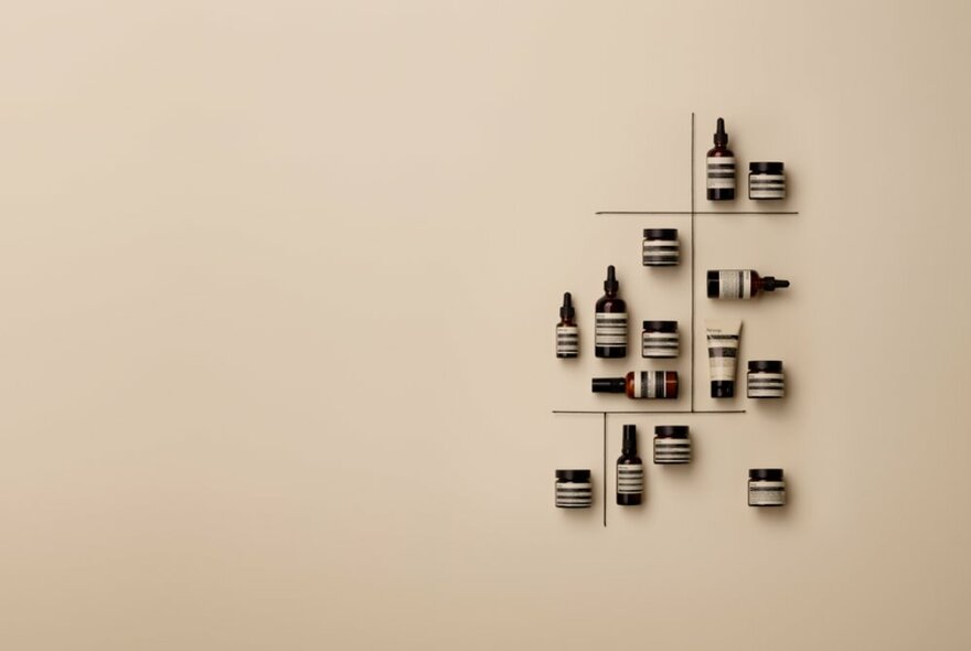 A small display of Aesop products arranged at different angles on a wall