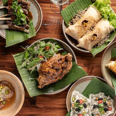 A set banquet of several Filipino cuisine dishes, served on a wooden table. 