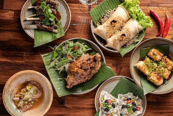 A set banquet of several Filipino cuisine dishes, served on a wooden table. 