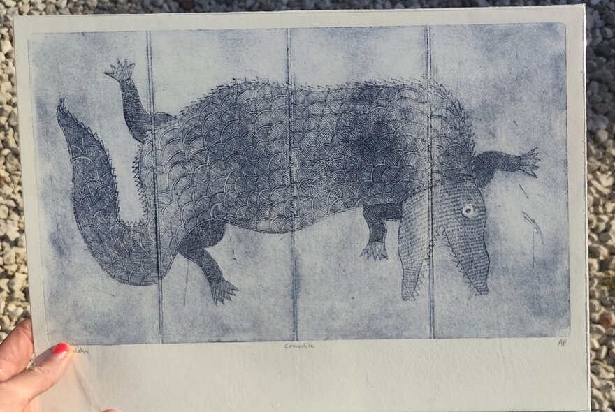 Hand holding a printed image of an animal.