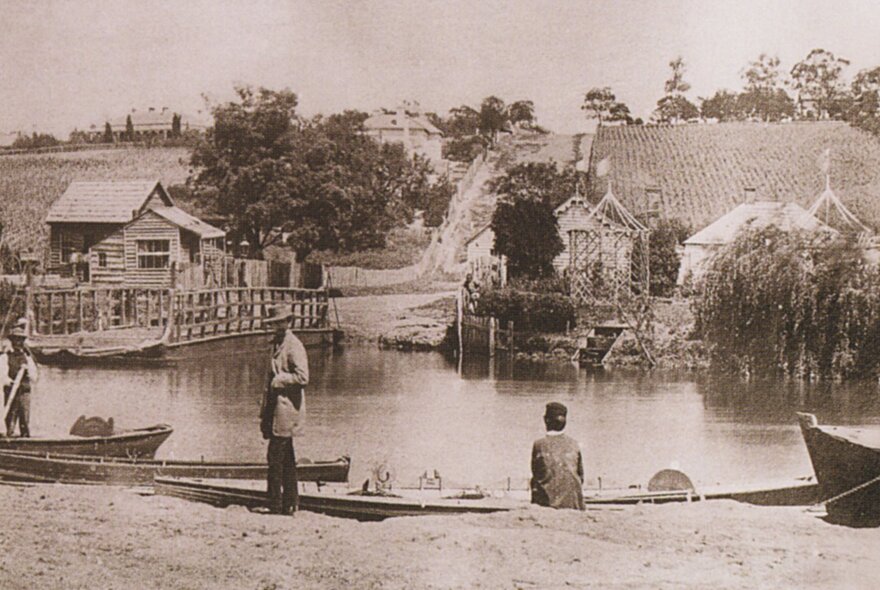 Historic photo of people on the banks of the Yarra with boats, at the location where Punt Road crosses the river today.