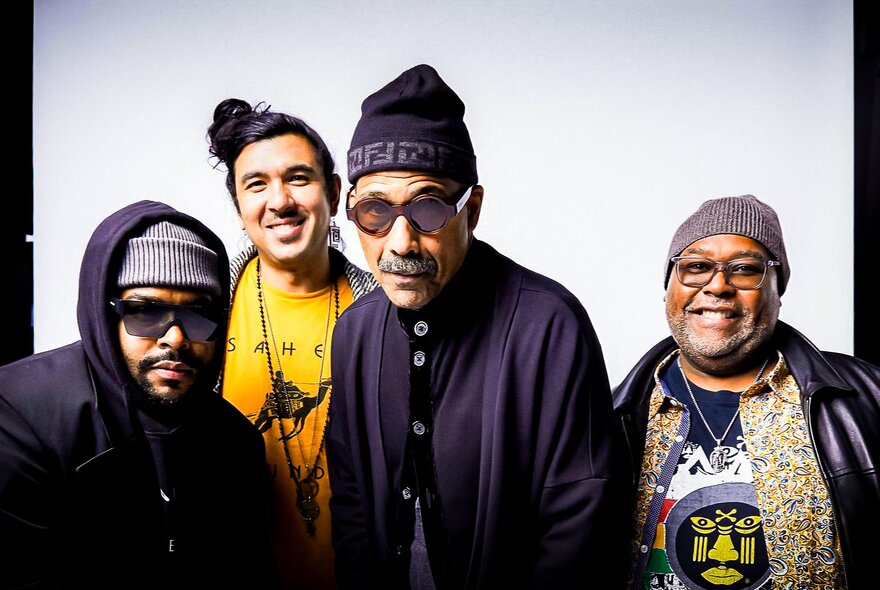 Four members of the jazz ensemble Ethnic Heritage Ensemble, posing against a white background. 