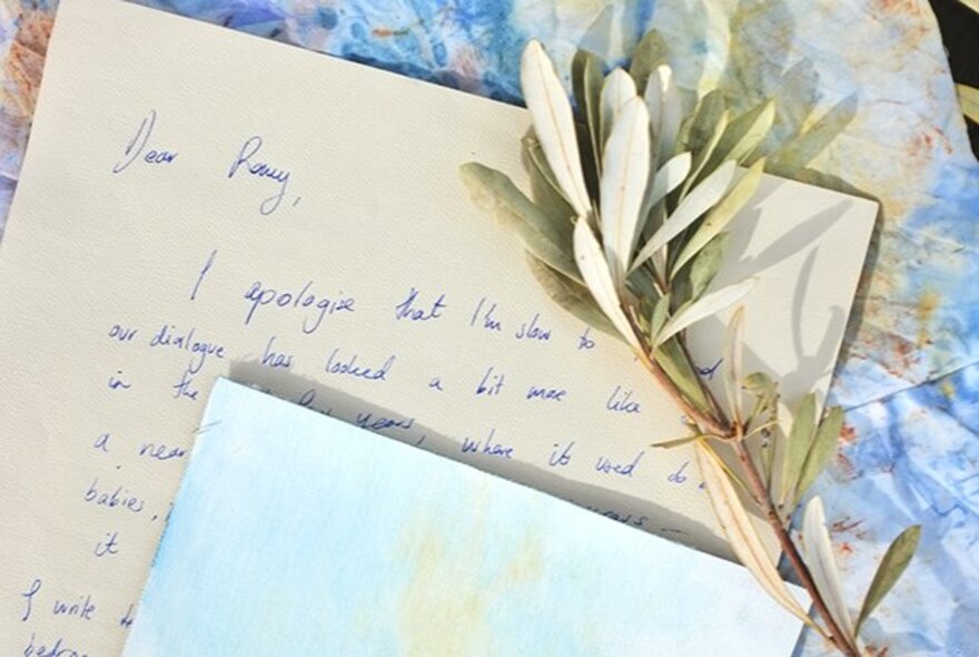 Artwork of handwritten letters with dried frond.