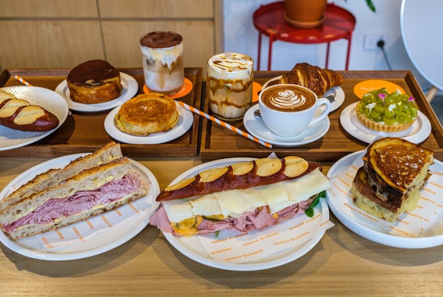 A table full of baguettes, tarts and coffee