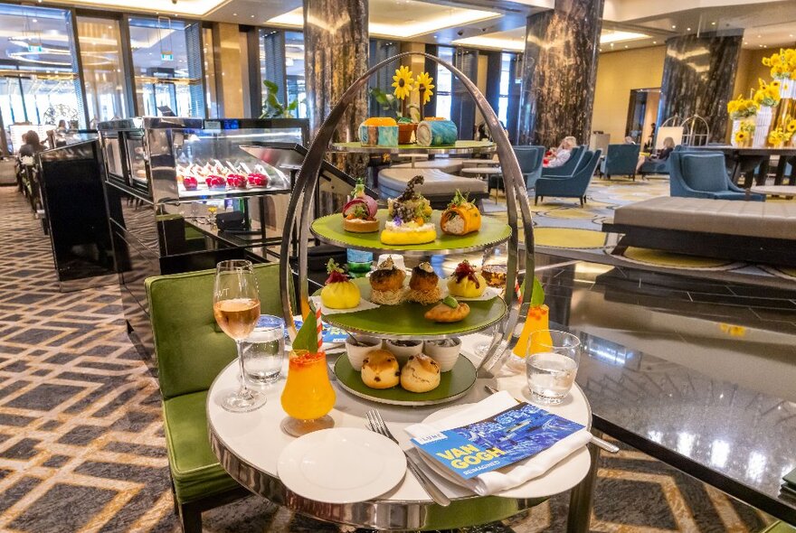A four-tier cake stand with Van Gogh-inspired desserts and orange cocktails.