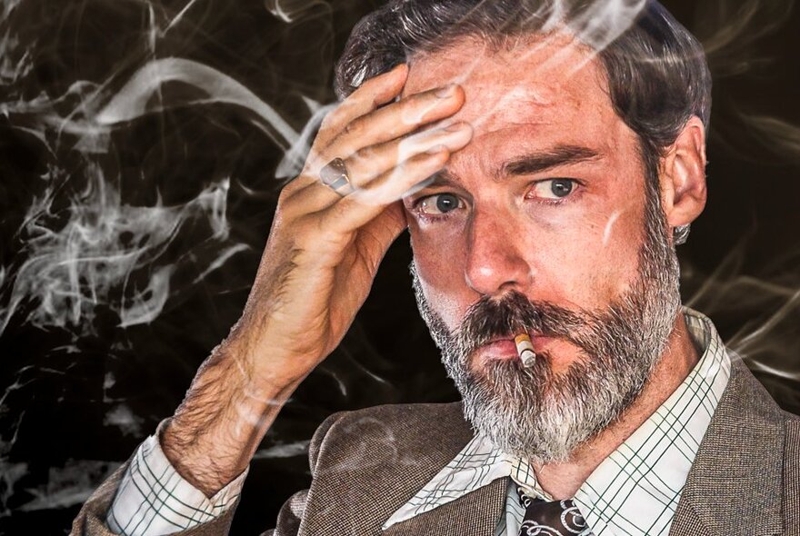 Actor smoking the tail end of a cigarette, his hand to his brow, the air full of smoke.