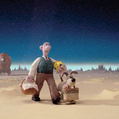 A still image from the short film Wallace and Gromit – A Grand Day Out, showing the two leads walking across the surface of the moon with their rocket ship behind them. 