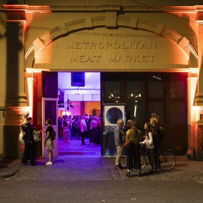 Meat Market venue at night, with purple-lit interior glimpsed through arched opening.