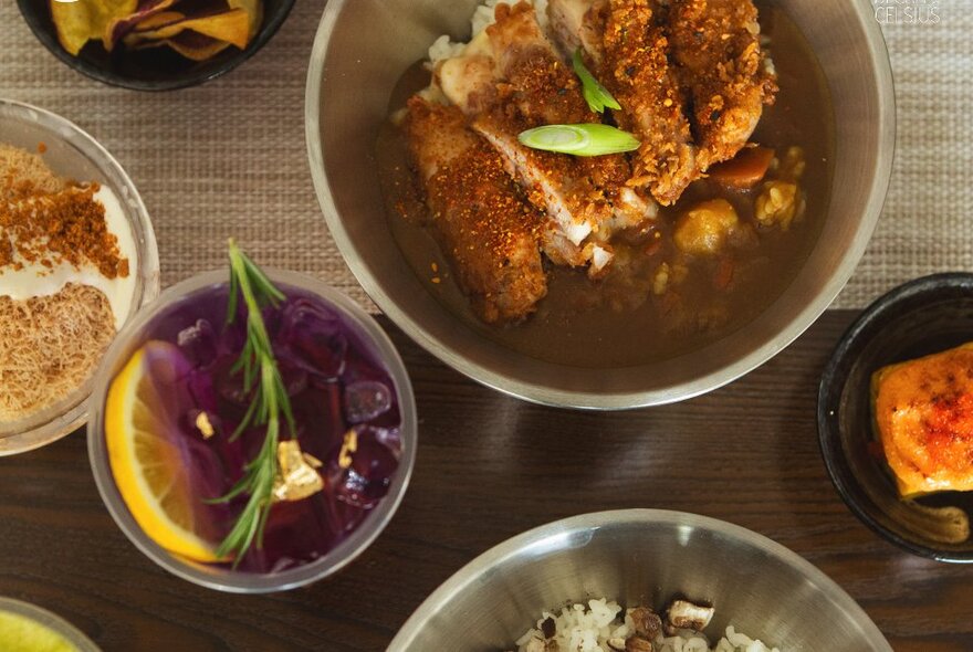 Stainless-steel dishes of food including fried chicken.