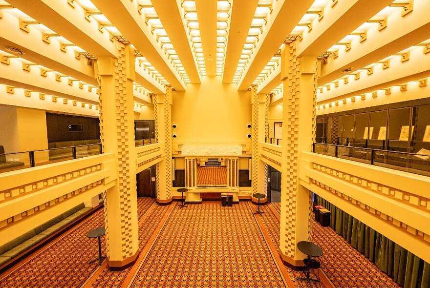 Inside an art deco movie theatre with an ornate ceiling