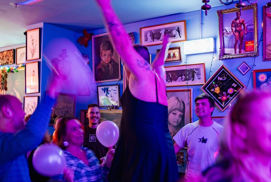 Peter Baecker with arms in the air and people around smiling and holding balloons