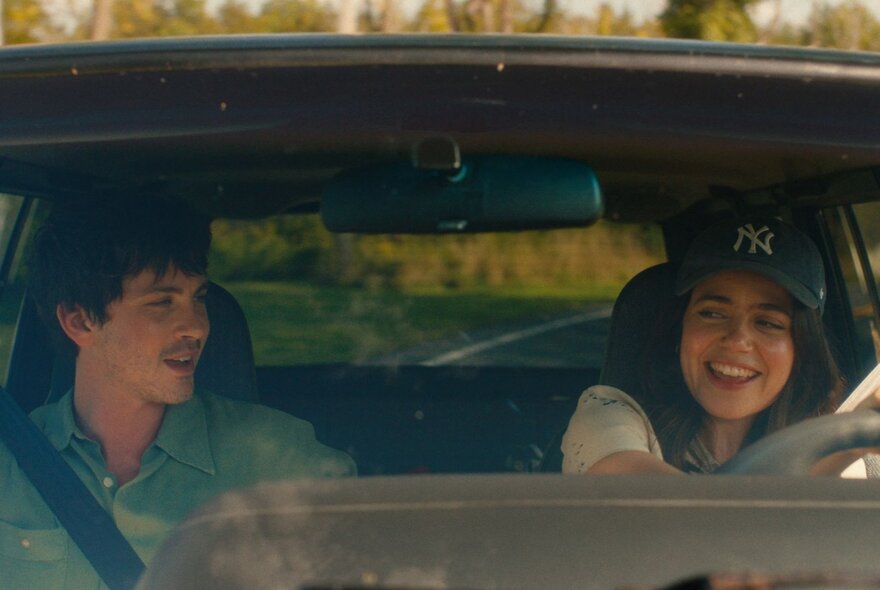 A still from the film, Oh, Hi! showing a young couple in a car, seen through the windshield, the woman driving.