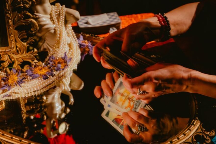 A tarot card reading with cards shown on a mirrored surface.