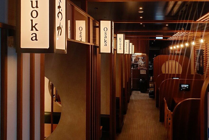 A restaurant interior with wooden booth seating.