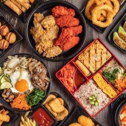 Looking down on a table full of an assortment of Korean dishes. 