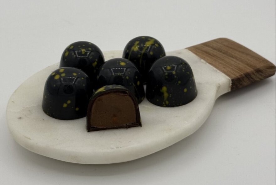 A selection of decadent chocolates presented on a marble tablet.