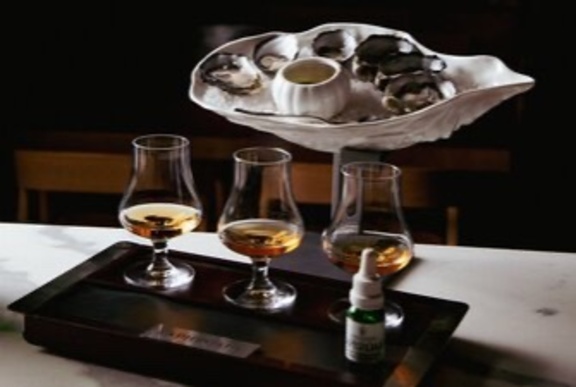 Tray of oysters with glasses of whisky.