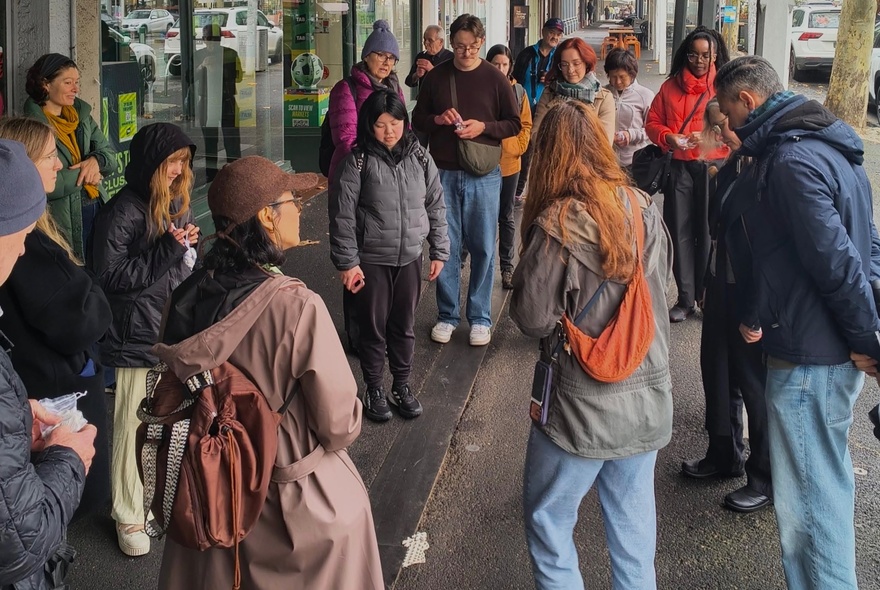 People gathered in a group outdoors wearing winter clothing.