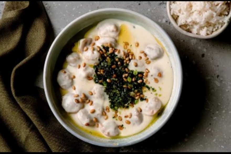 A creamy pasta dish with chopped microgreens as garnish.