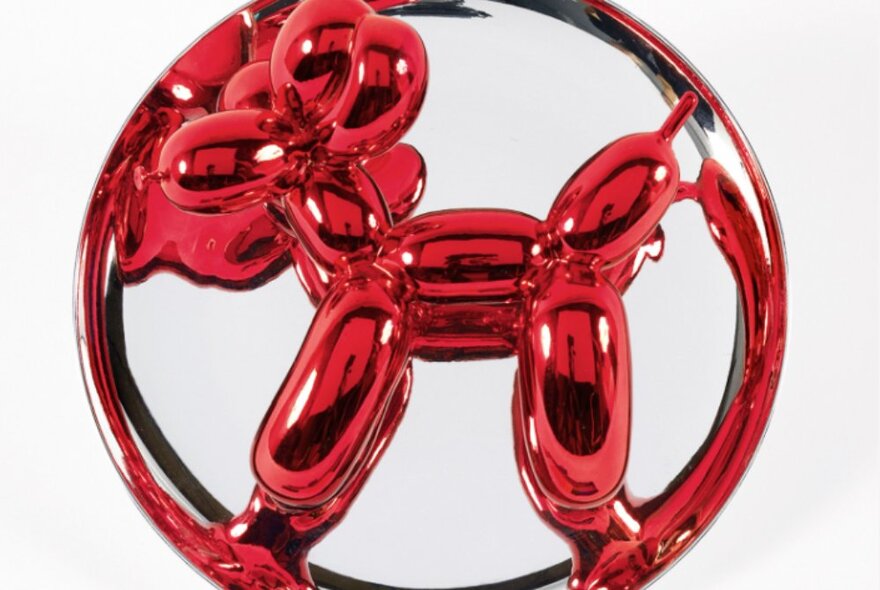 Distinctive Jeff Koons sculpture of a red balloon animal shaped like a dog.