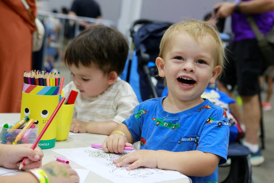 Two young children taking part in art and craft activities at a table at the Kids Day Out.