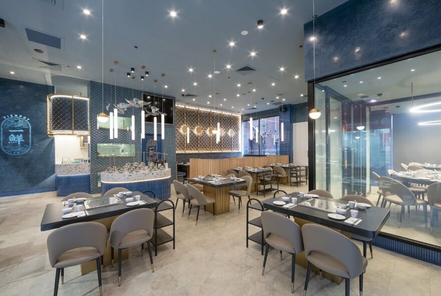 Interior of Fishpot restaurant showing tables and chairs and signage on the walls.