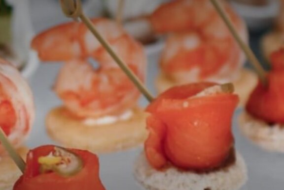 Rows of seafood appetisers on a platter.