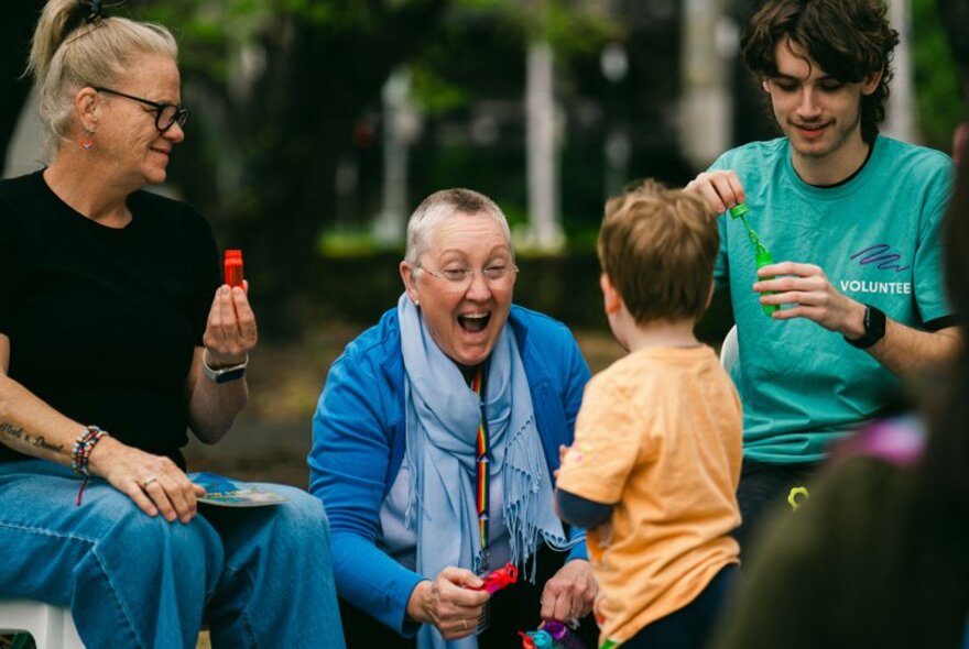 People enjoying themselves while blowing bubbles at an outdoor event.