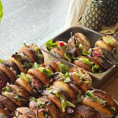 Two trays of small sliders or sandwiches