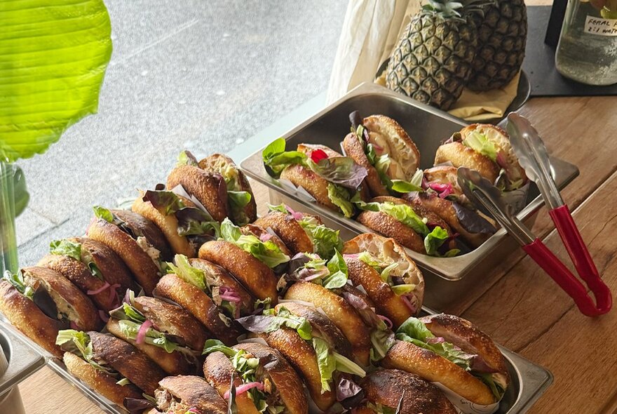 Two trays of small sliders or sandwiches