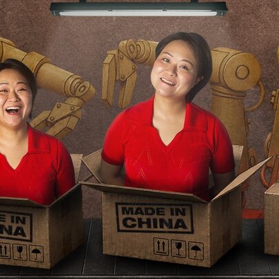 Comedian He Huang, her torso and head popping out of a box with a 'Made in China' stamp.