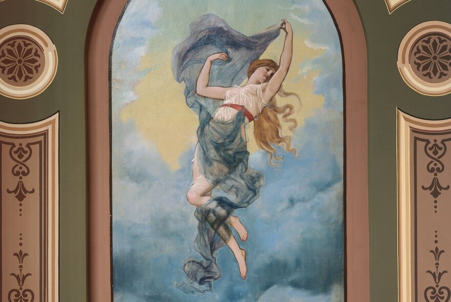 Detail on the walls of the Royal Exhibition Building showing a woman floating in the sky with robes and hair flowing