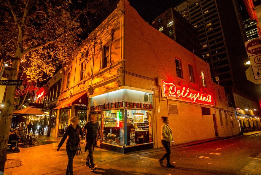 Outside an Italian restaurant at night. There is a neon sign saying Pellegirni's. 